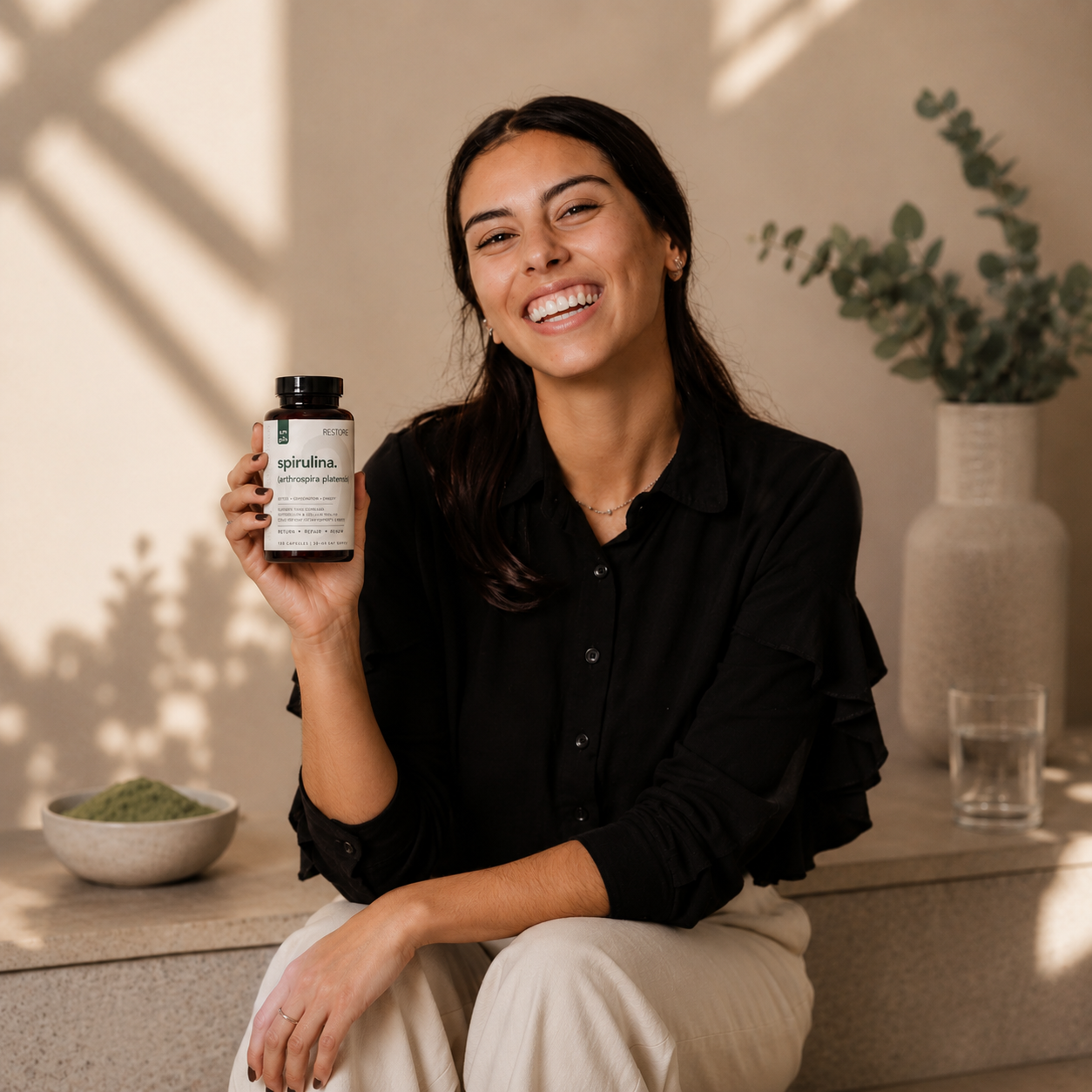 Woman holding a supplement bottle in a home setting with plants and decor.