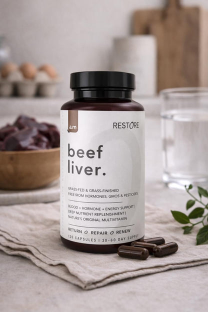 Supplement bottle labeled 'beef liver' on a table with a neutral background